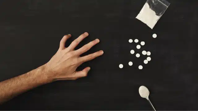 Hand reaching for spilled drugs