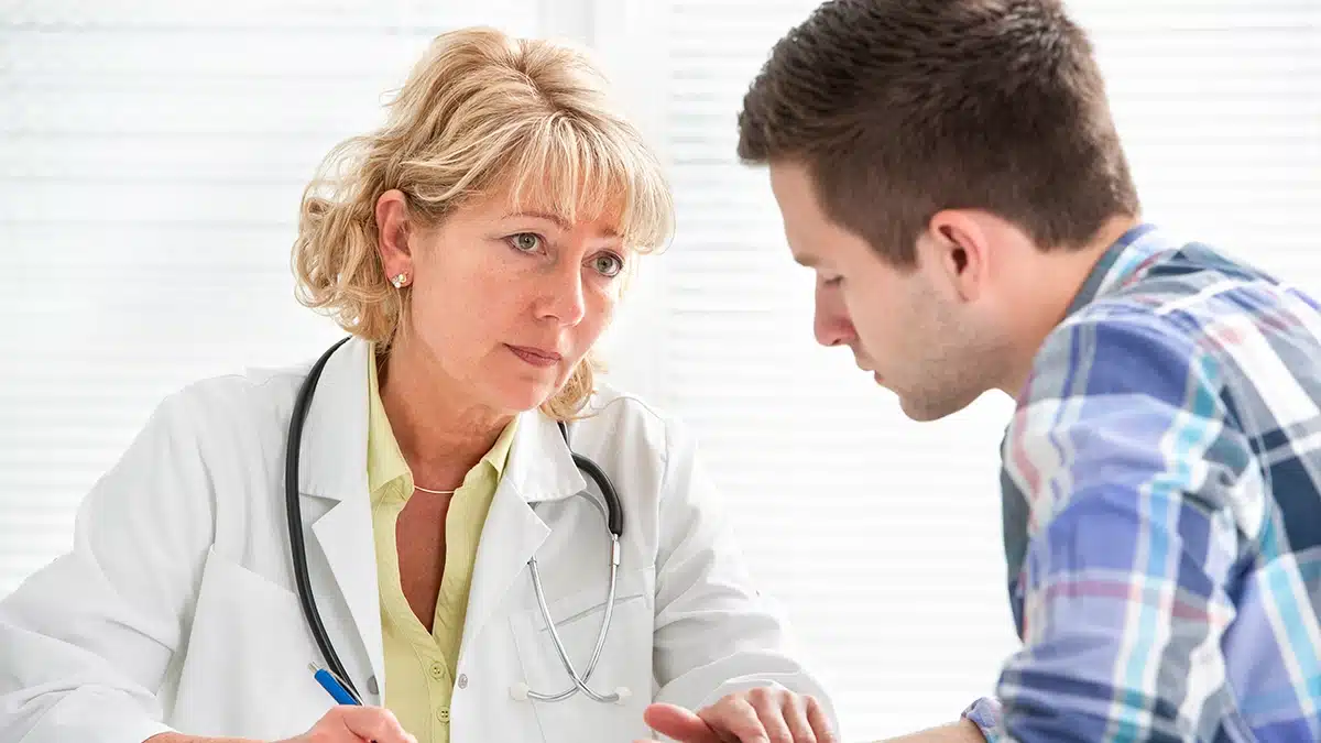 A doctor having a serious conversation with a patient, focusing on understanding the patient's specific treatment needs in a medical setting