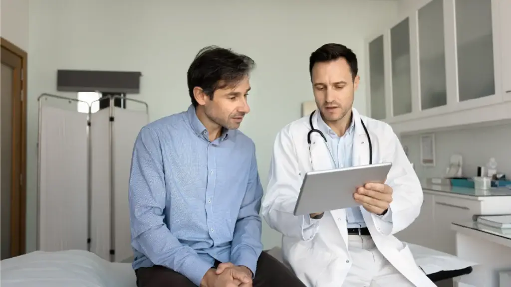Doctor talking to his patient as he points to something on his portable device