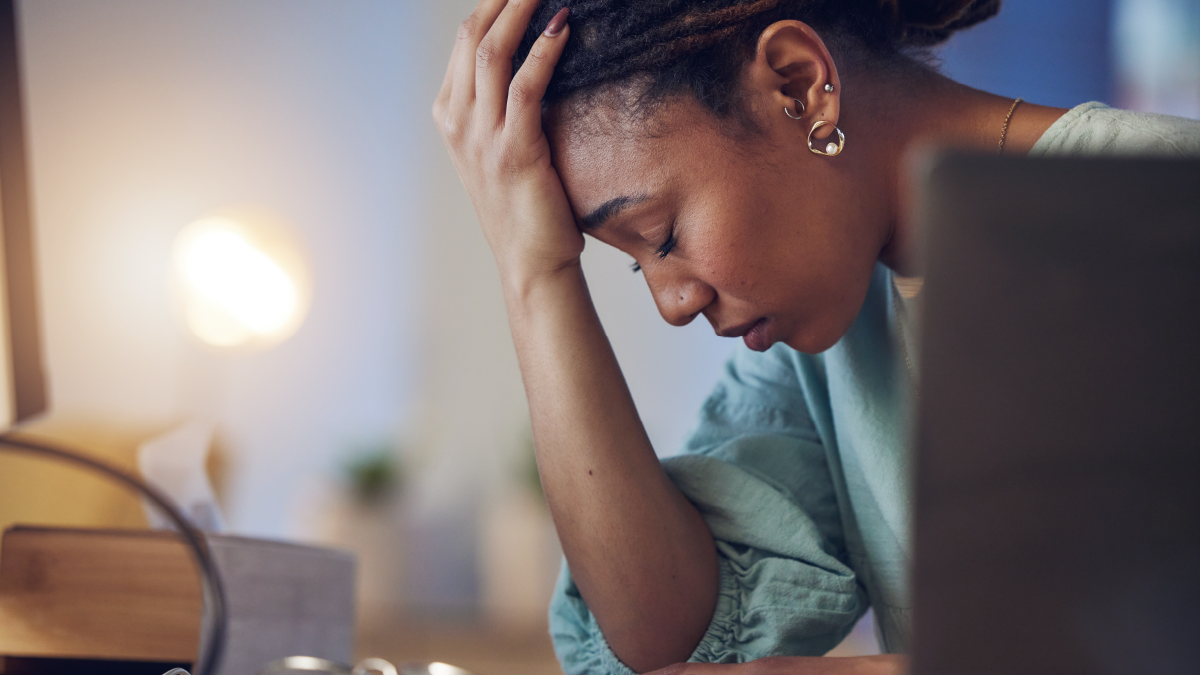 distressed woman with head on her forehead