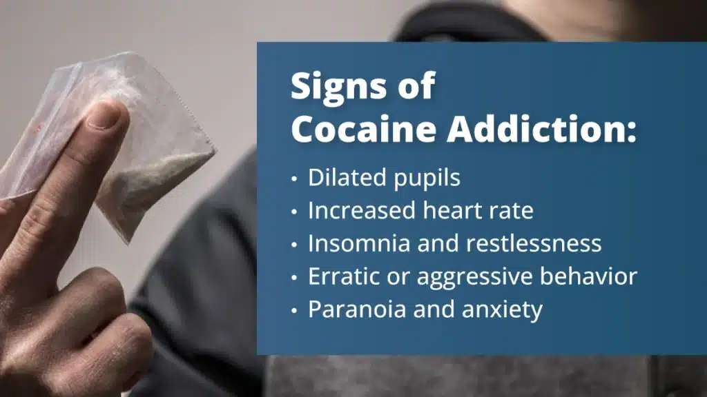 A man holding a small bag of white powder between two fingers. White text in a blue text box lists signs of cocaine addiction.
