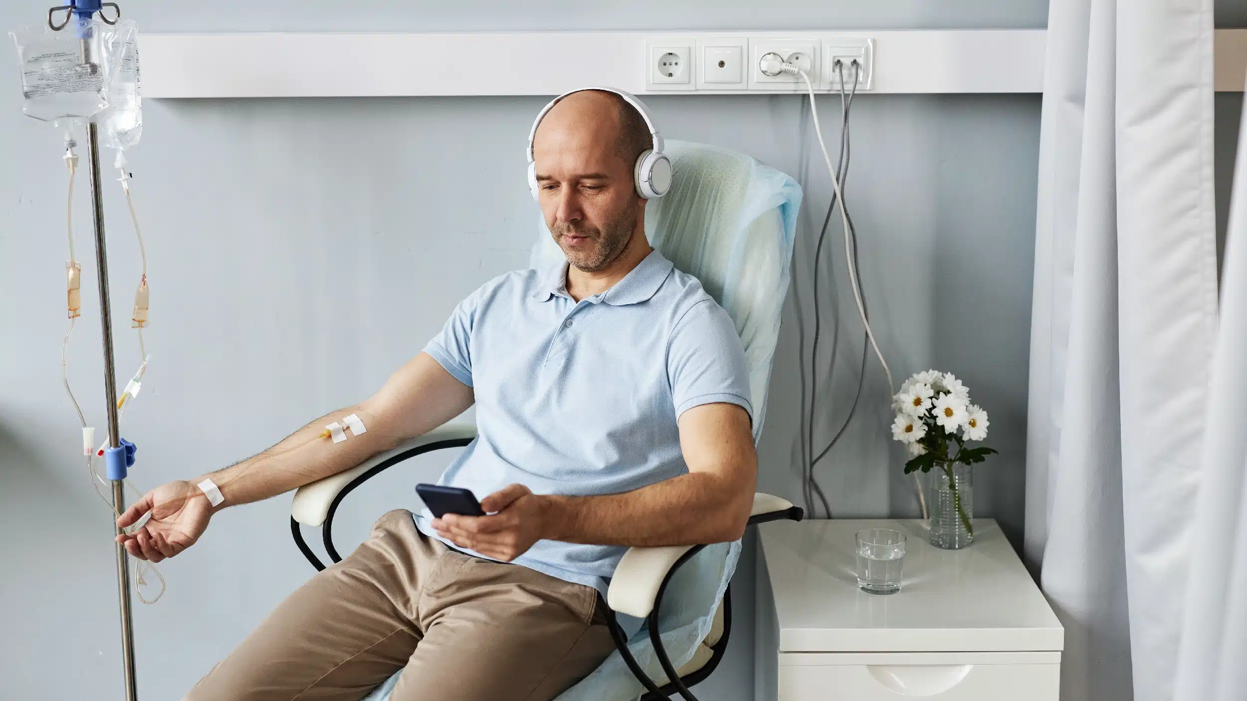 Man wearing headphones receiving an IV.