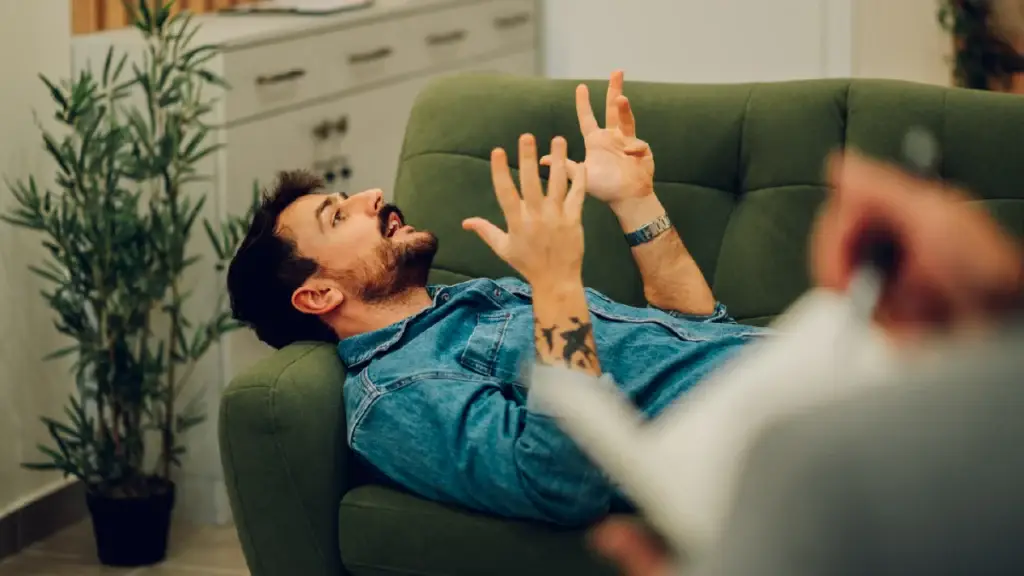 man in frustration sitting on a couch looking a the ceiling