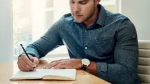 man writing notes
