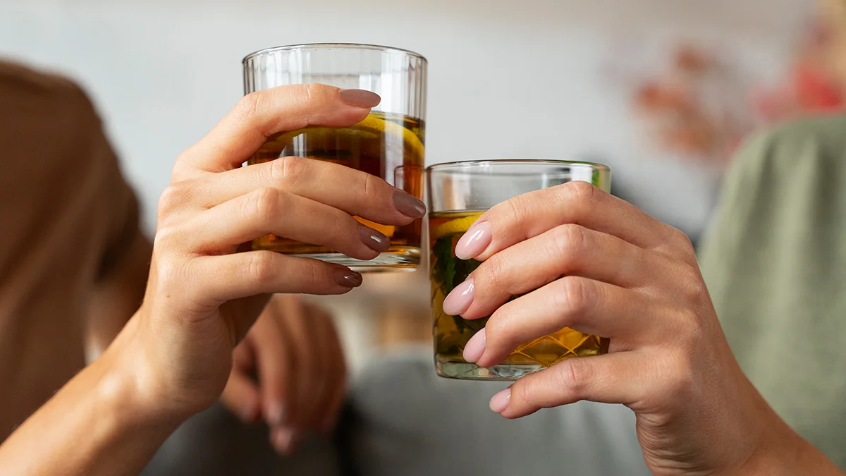 Two people cheering with glasses of alcohol