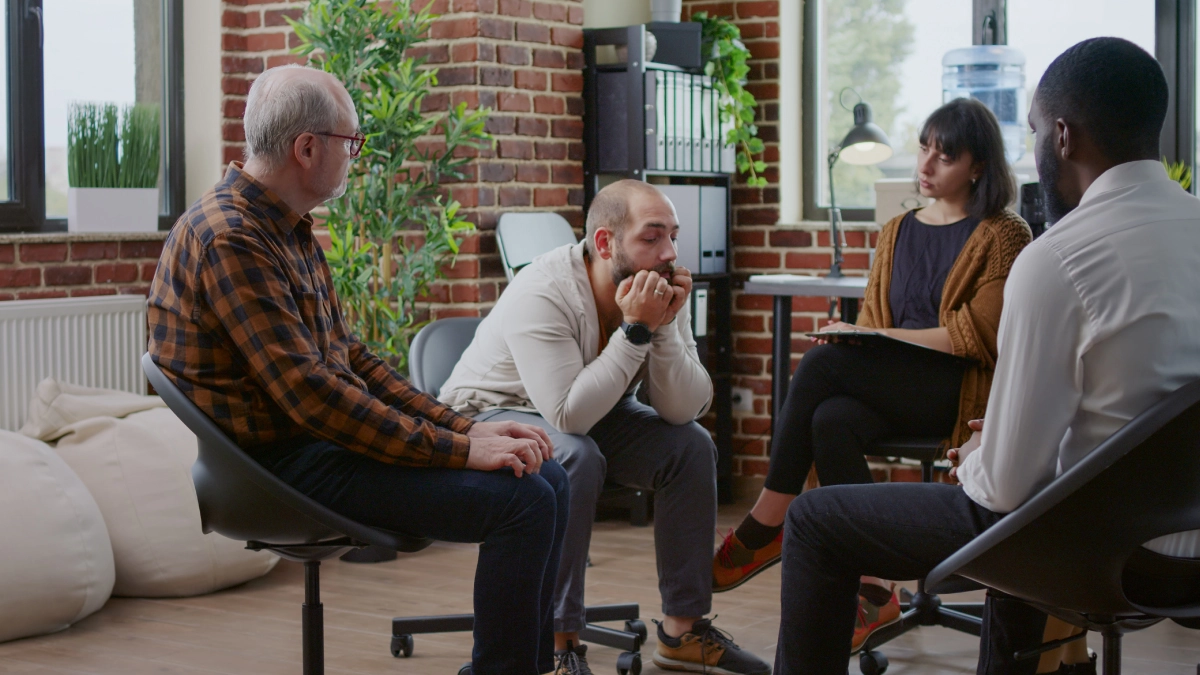 A support group session in a well-lit, cozy room.