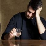 anguished man with a glass of alcohol in his hand