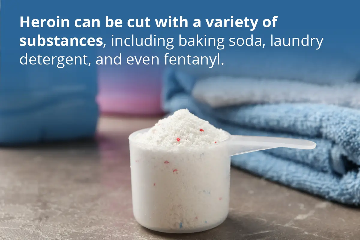 A plastic scoop filled with powdered laundry detergent is placed on a countertop, with folded blue towels and detergent containers in the background. Over a blue gradient at the top of the image, white text reads: "Heroin can be cut with a variety of substances, including baking soda, laundry detergent, and even fentanyl."