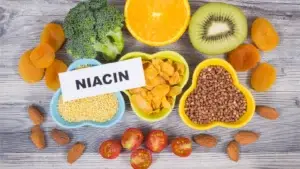 A flat lay of various niacin-rich foods on a wooden surface.