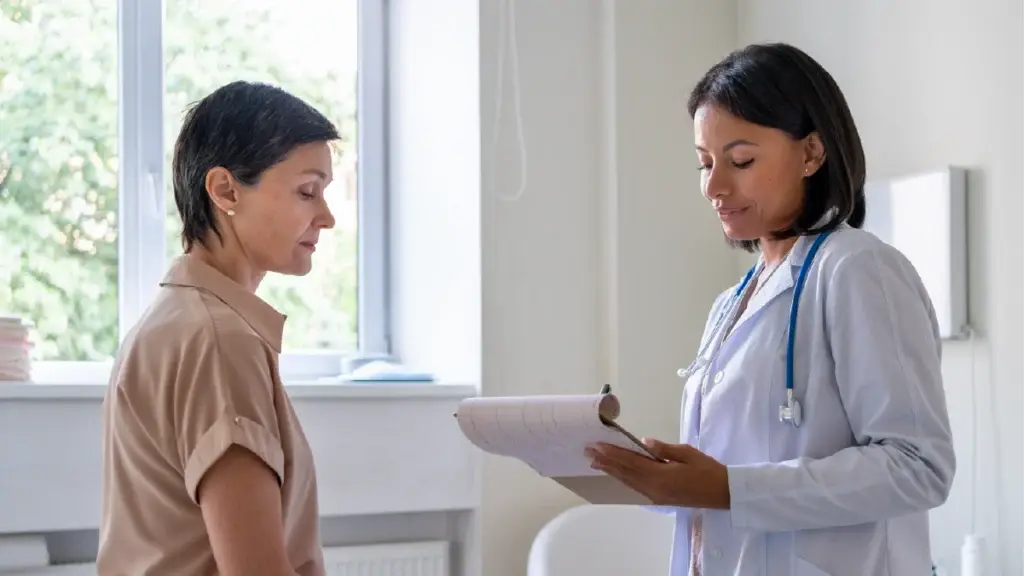 Doctor talking to a patent with a clipboard in her hand as her patient observes attentively.
