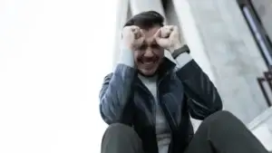 Frustrated man with two of his clenched fists pressed on his forehead