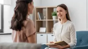 Woman talking to a nurse sitting ona couch