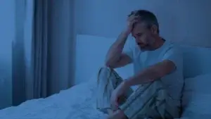 saddened man on his bed at night