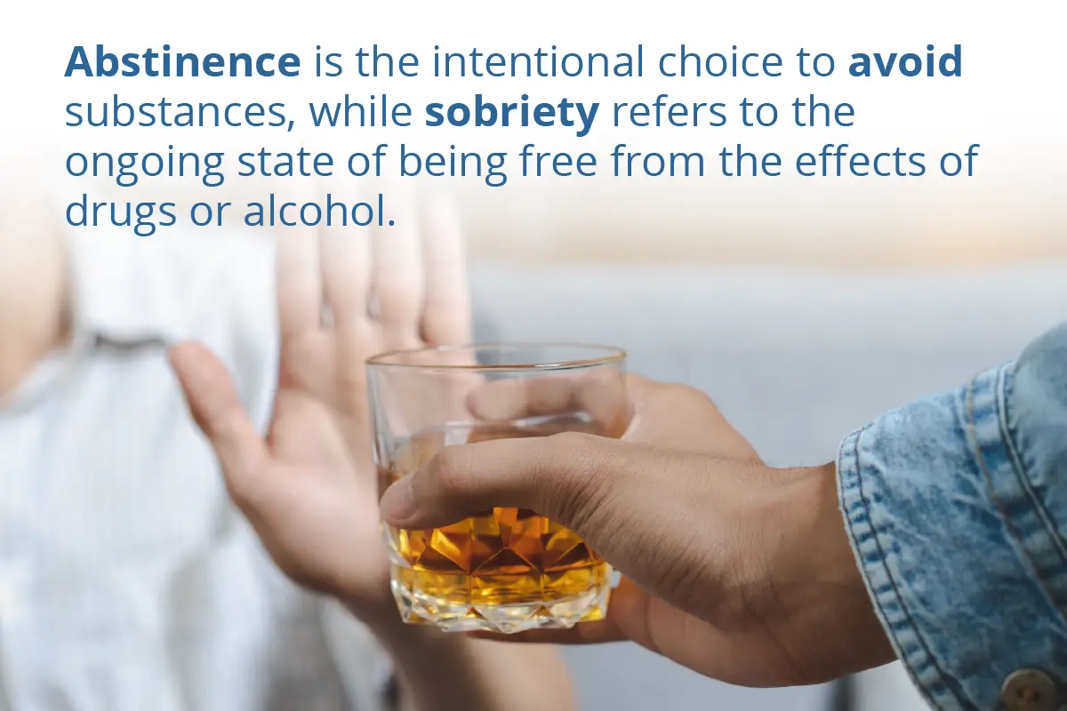 person denying a glass of alcohol wiht their hand