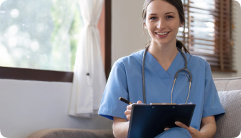 Nurse happily looking forward with a pen and clipboard in her hand