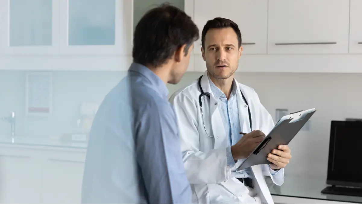 A doctor talking to a patient with a clipboard in his hand