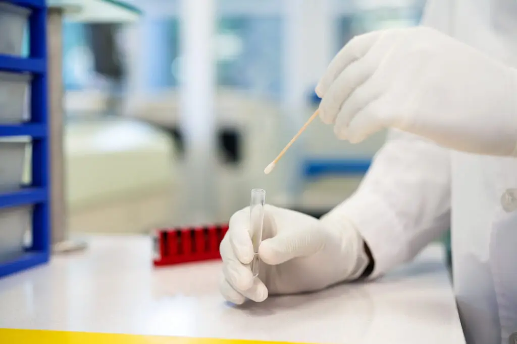 GenesSight results being handled in a laboratory setting by a professional wearing white gloves and a lab coat