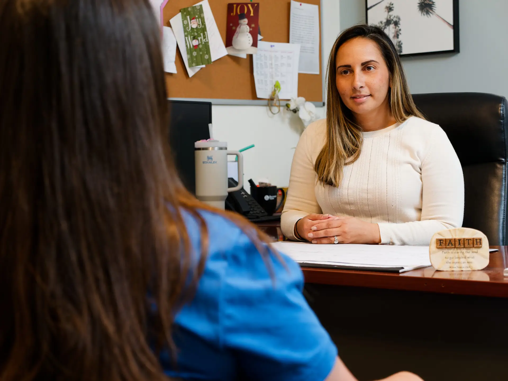 Female counselor meeting with patient in a private office at a drug and alcohol rehab center, providing supportive addiction treatment and recovery planning