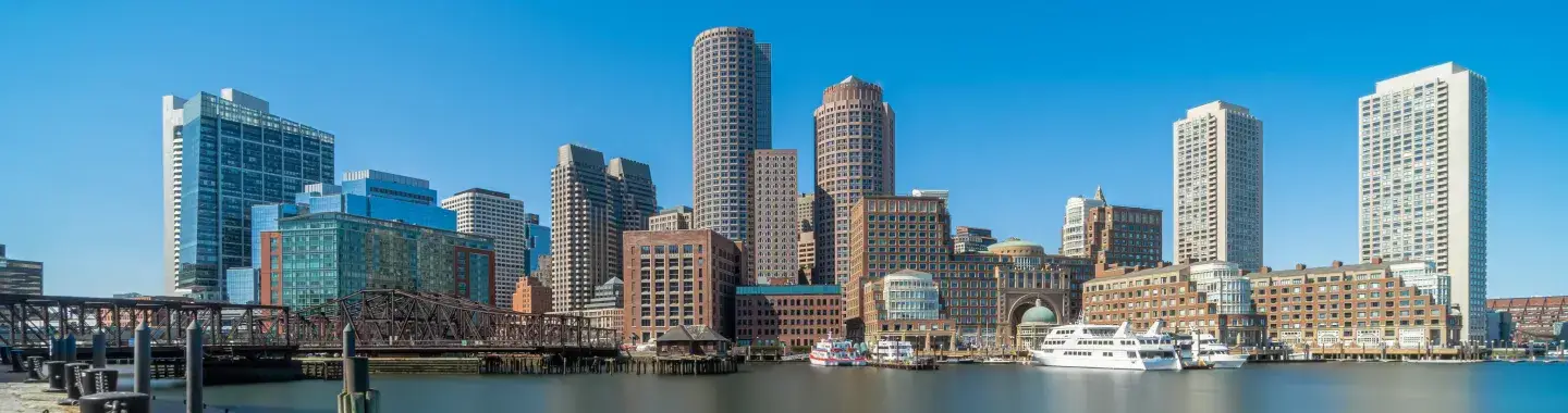 A Massachusetts skyline with several boats in the frame.