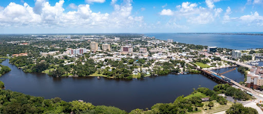 Aerial view of waterfront city with river and surrounding neighborhoods.