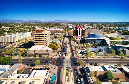 Arizona — aerial view of city street with tall buildings and desert landscape.