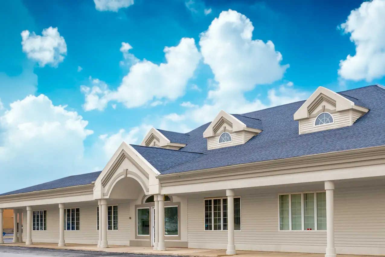 Exterior of an Indiana treatment center building under a bright blue sky with scattered clouds.