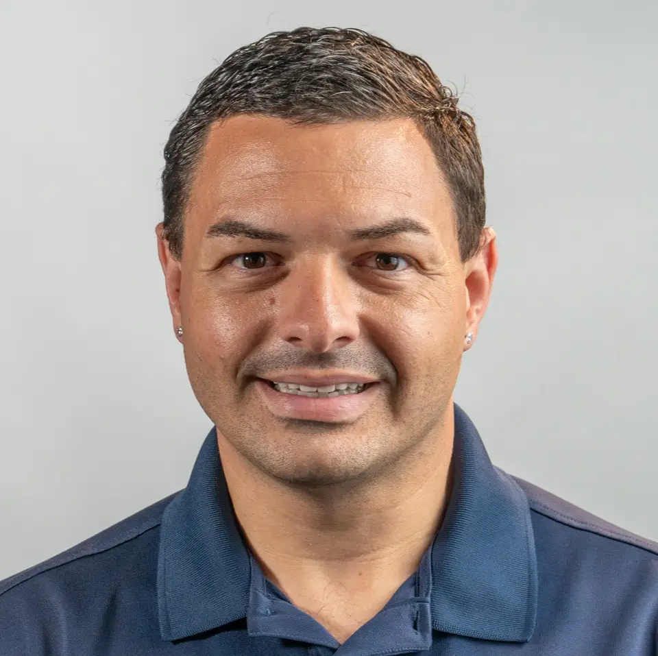 Portrait of a man with short hair in a collared shirt.