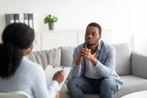 Therapist speaking with a client during a one-on-one counseling session in a calm, modern treatment setting.