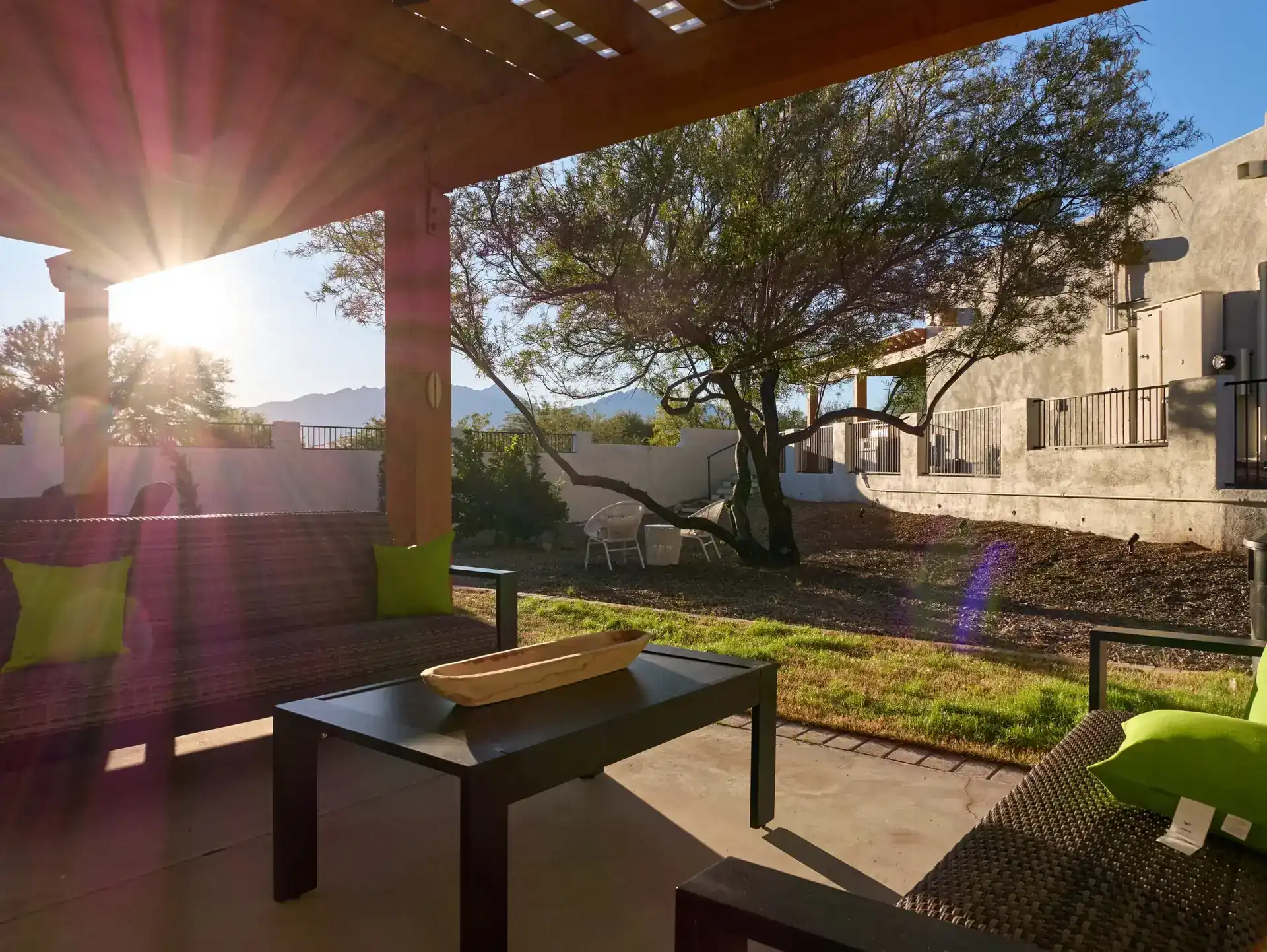 Outdoor patio at The Haven Detox Arizona with seating area, desert landscaping, and sunlight filtering through pergola at the treatment facility