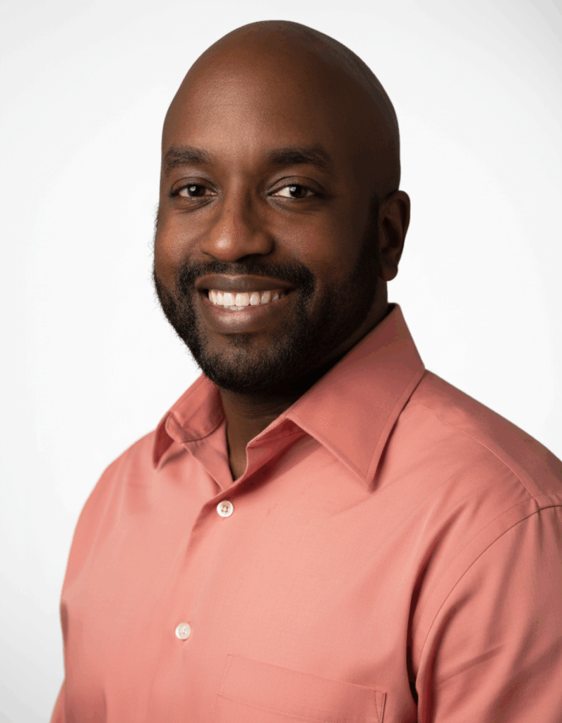 Professional headshot of the executive director of Haven Detox Oklahoma, smiling and wearing a coral button-down shirt, representing leadership at an Oklahoma drug and alcohol detox treatment center.