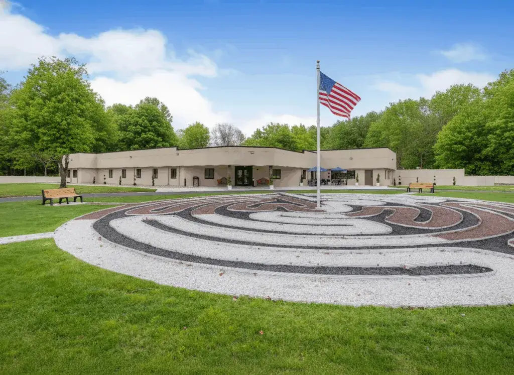 Aerial view of The Haven Detox New Jersey facility featuring a circular walking labyrinth, American flag, and surrounding green landscape.