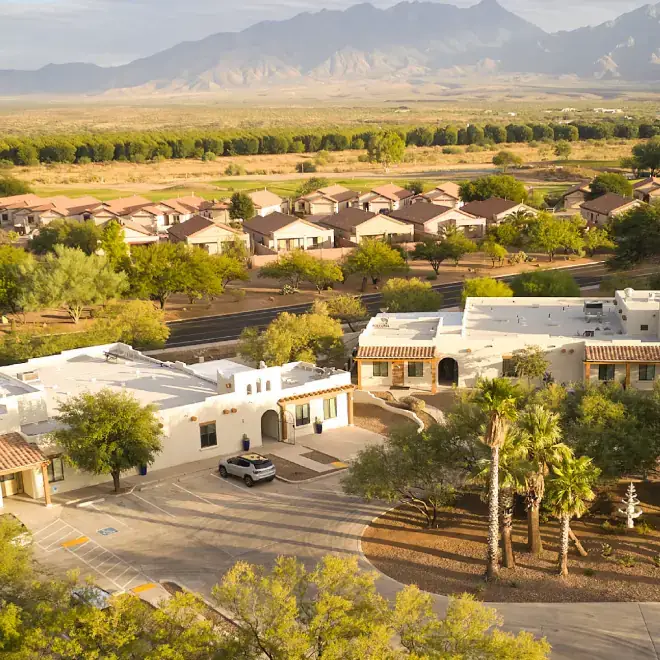 Aerial view of The Haven Detox Arizona campus featuring modern buildings, desert landscaping, palm trees, and surrounding mountain scenery