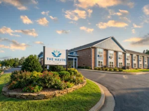 Entrance signage at The Haven Detox Oklahoma surrounded by flowers and warm exterior colors