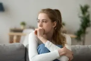 una mujer sentada sola en su sofá